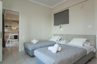 two beds in a room with a kitchen at Popy's Place in Kato Daratso