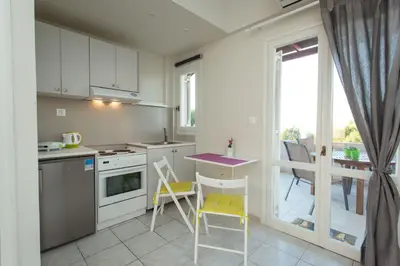 a kitchen with a table and chairs and a window at Popy's Place in Kato Daratso