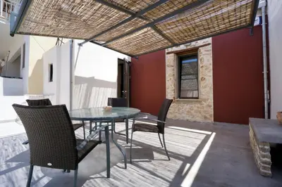 a patio with a glass table and chairs on it at Evans House in Chania Town