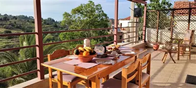 a wooden table with bananas on a balcony at Aoria Traditional House with Stuning Mountain View in Loúlos