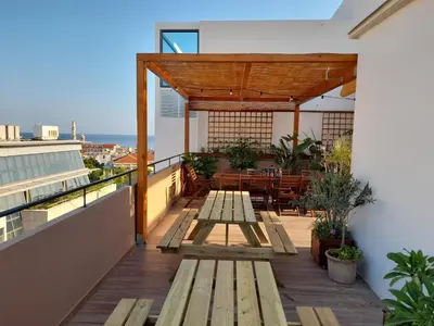 a balcony with wooden picnic tables on a building at ChaniaStay Central Apartments in Chania Town