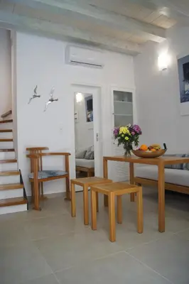 a living room with wooden benches and a table at Casa al Bocca del Porto in Chania Town