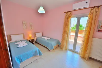 a bedroom with two beds and a balcony at Eliana in Kissamos
