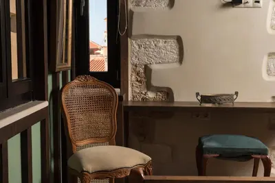 a chair sitting next to a table with a window at Nonnalena Boutique Hotel in Chania Town