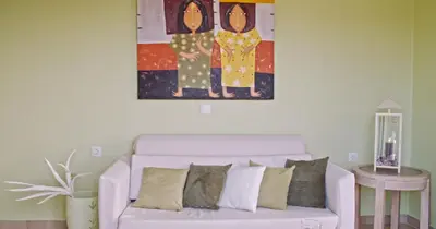 a living room with a couch and a painting on the wall at Waterlily Hotel Apartments in Kalathas