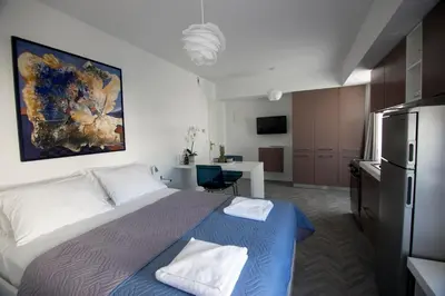 a bedroom with a bed and a kitchen with a refrigerator at DYO Urban Chania in Chania Town