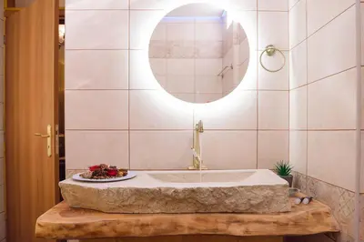 a bathroom with a tub and a plate of fruit on a table at Villa Roxani in Mesklá
