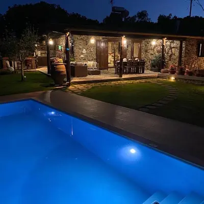 a swimming pool with blue lights in a backyard at night at Villa Casa Avocado in Tavronitis