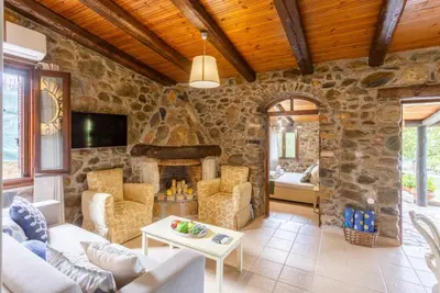 a living room with a stone wall at Villa Casa Avocado in Tavronitis