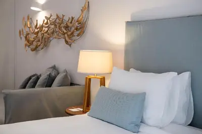 a bedroom with a bed with a lamp and a couch at Avra Apartments Venetian Harbour in Chania Town