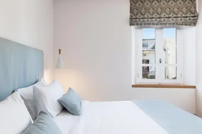a bedroom with a white bed with a window at Avra Apartments Venetian Harbour in Chania Town