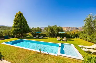 a swimming pool in the yard of a house at Villa Dimitris in Vlikhádha