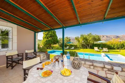 a patio with a table and a swimming pool at Villa Dimitris in Vlikhádha