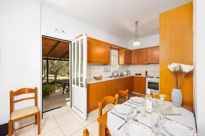 a kitchen with a table and chairs and a dining room at Villa Dimitris in Vlikhádha