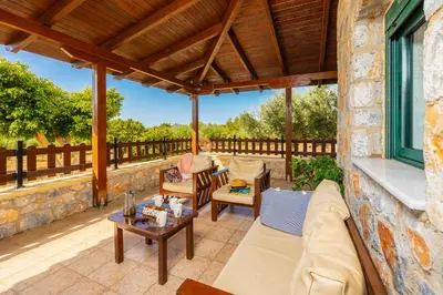 an outdoor patio with a couch and chairs and a table at Theo Beach Villa in Frangokastello