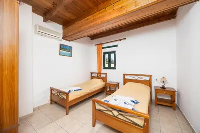 a bedroom with two beds and a wooden ceiling at Theo Beach Villa in Frangokastello