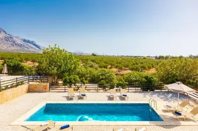 a swimming pool with a view of a vineyard at Theo Beach Villa in Frangokastello