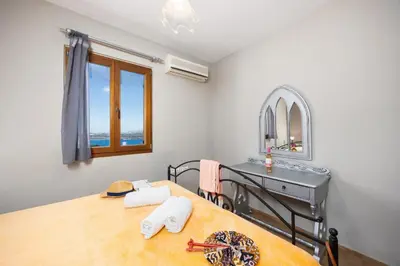 a bedroom with a table and a vanity and a mirror at Villa Neria in Áptera