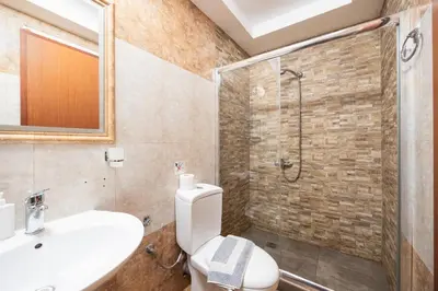 a bathroom with a shower and a toilet and a sink at Villa Neria in Áptera