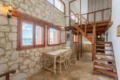 a room with a table and some windows and a staircase at Souda Bay View in Kalami