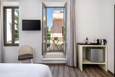 a bedroom with a bed and a view of a balcony at Shalom Luxury Rooms Daliani in Chania Town
