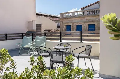 a patio with chairs and a table on a balcony at Shalom Luxury Rooms Daliani in Chania Town