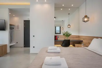 a bedroom with a large bed and a living room at Central City Hotel in Chania Town