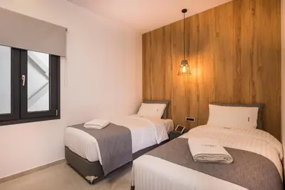 a bedroom with two beds and a window at Central City Hotel in Chania Town