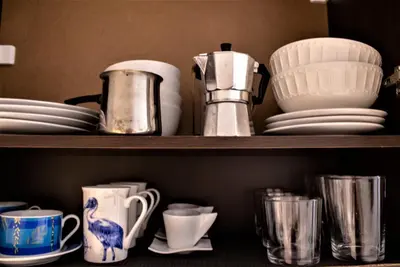 a shelf filled with plates and cups and dishes at Estrella Studios in Chania Town