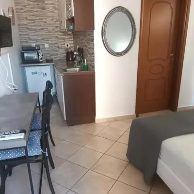 a small kitchen with a table and a mirror at Estrella Studios in Chania Town