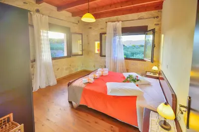 a bedroom with a large bed with a red blanket at Villa Athina in Kissamos