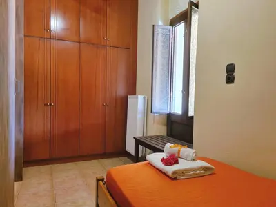a bedroom with a bed with orange sheets and a window at Villa Athina in Kissamos