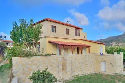 a house behind a stone wall at Villa Athina in Kissamos