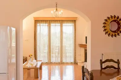 a living room with a large window and a table at Ortaki Traditional House in Loúlos