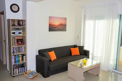 a living room with a couch and a table at Olive Tree Hillside Apartment in Stalos