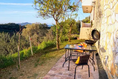 a table and chairs on a patio with a view at Olive Tree Hillside Apartment in Stalos
