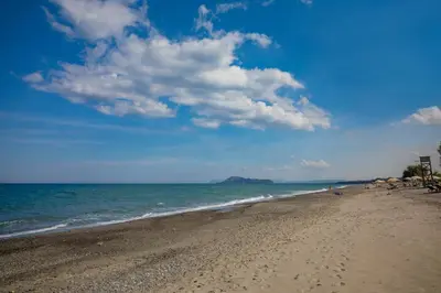 a beach with the ocean and a blue sky and clouds at The Olive House in Kondomari