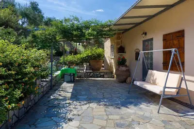a patio of a house with a swing at The Olive House in Kondomari