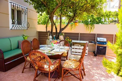 a patio with a table and chairs under a tree at Villa Galata in Galatás
