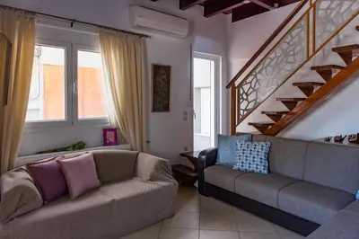a living room with a couch and a staircase at Villa Galata in Galatás