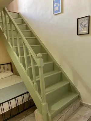 a green staircase with a bed in a room at Chrynigema in Chania Town