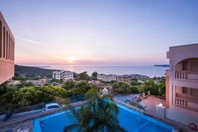 a view of the sunset from the balcony of a hotel at Esplanade Apartments - Heated Pool in Kalathas