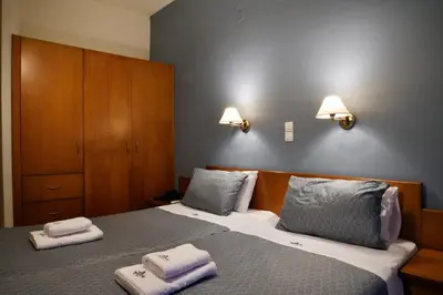 a bedroom with a bed with two towels on it at Akatos Hotel in Agia Marina Nea Kydonias