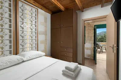 a bedroom with a white bed and a sliding glass door at Villa Piedra in Manoliópoulon