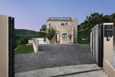 a gate leading to a house with a building at Villa Piedra in Manoliópoulon