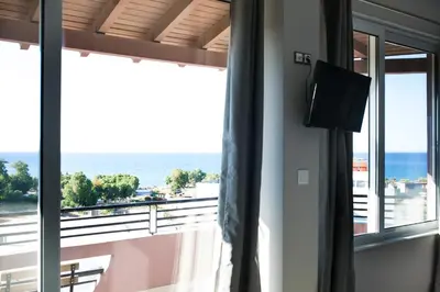 a room with a window with a view of the ocean at Yasmine Apartments and Rooms in Kato Daratso