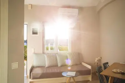 a living room with a couch and a window at Yasmine Apartments and Rooms in Kato Daratso