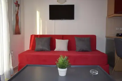 a red couch with two pillows on it in a living room at Astrantia in Chania Town