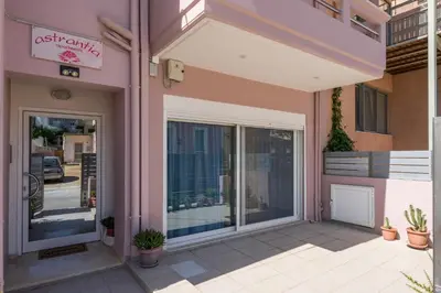 a pink building with glass doors and potted plants at Astrantia in Chania Town