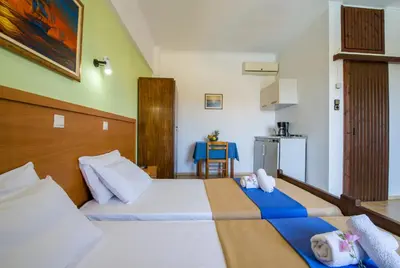 a hotel room with two beds and a kitchen at Studios Kydonia in Gerani Chanion